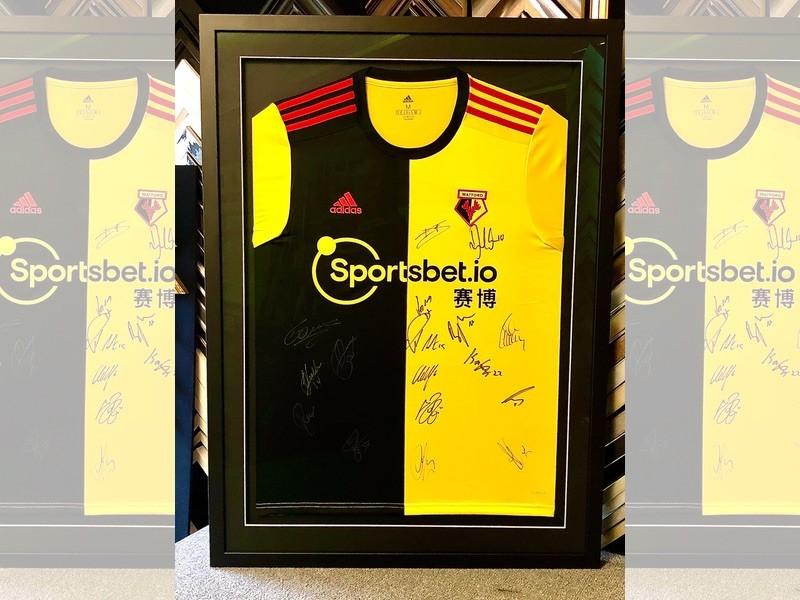 Signed Watford shirt, framed with a Matt black moulding, glazed with reflection control glass.
